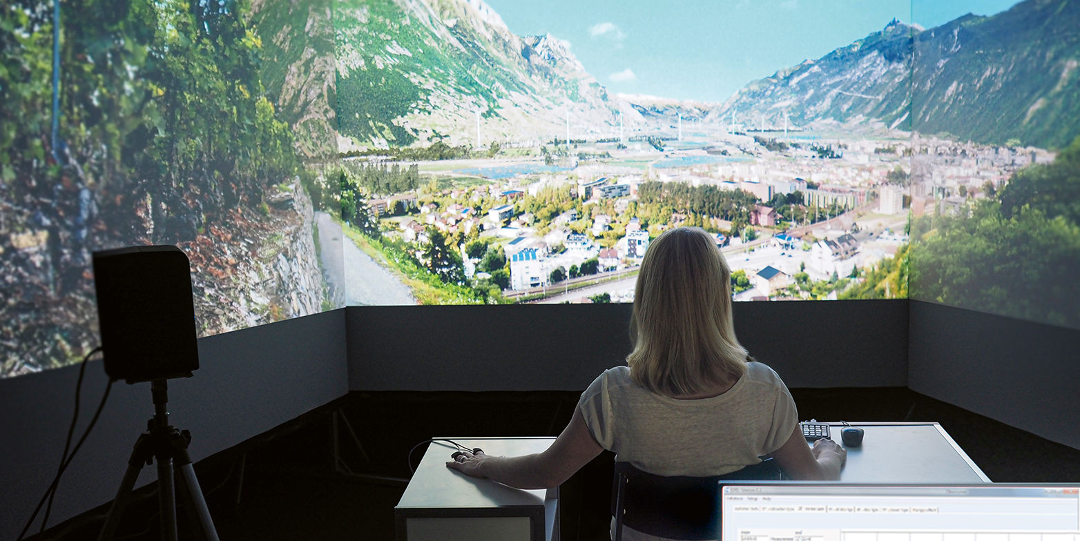 Eine Frau sitzt im Virtual Reality Lab mit Landschaftsbildern
