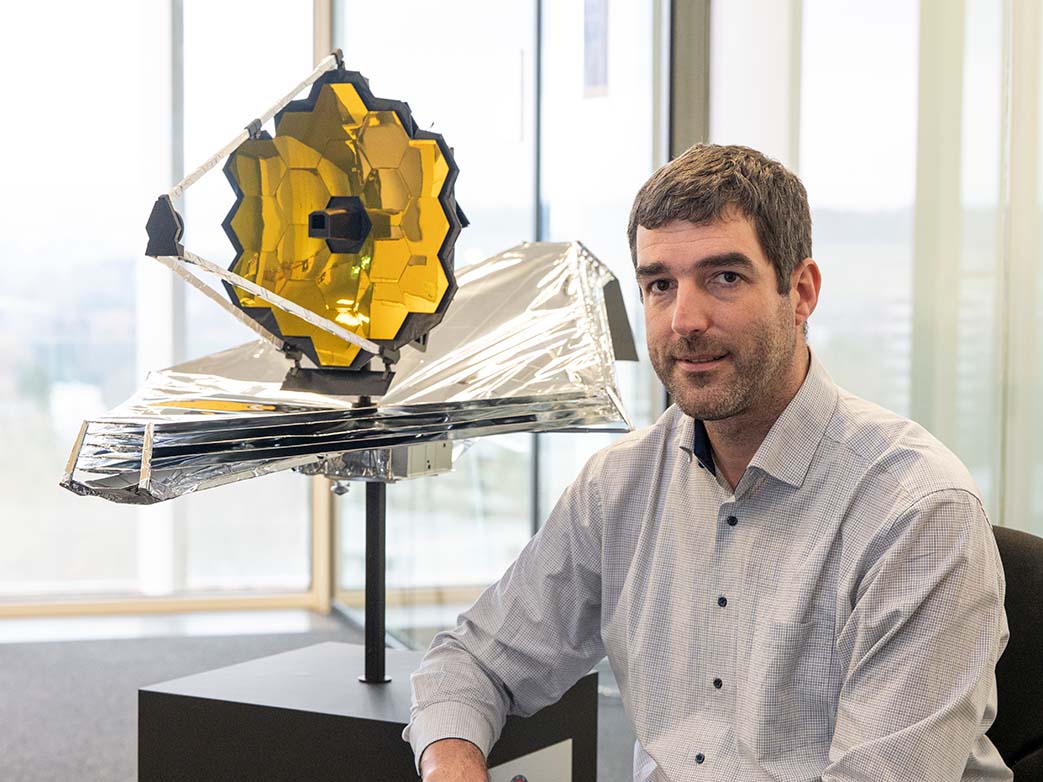 Adrian Glauser mit einem Modell des James Webb Space Telescope