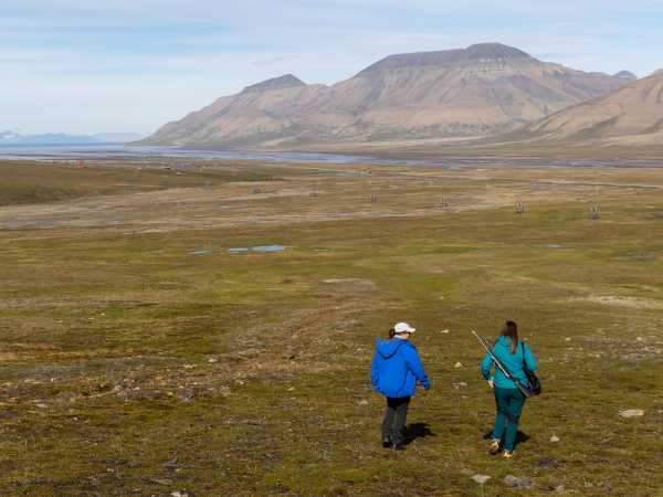 Vergr?sserte Ansicht: Zwei Frauen gehen ber die Tundra, im Hintergrund Berge und Meer