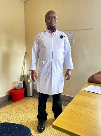 Ein afrikanischer Arzt in weissem Kittel welcher den Sensor tr?gt