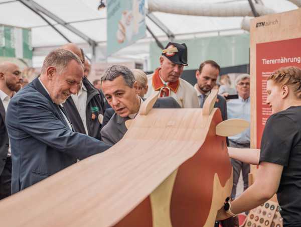 President Ignazio Cassis (in the center of the picture) stands behind a wooden cow together with Detlef Gnther (left).