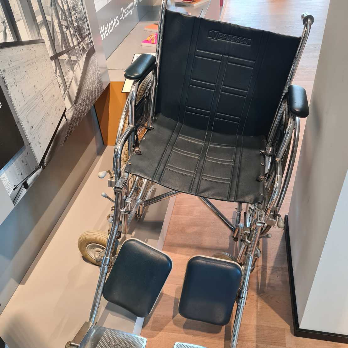 Ein Rollstuhl steht neben einer Säule in der Ausstellung