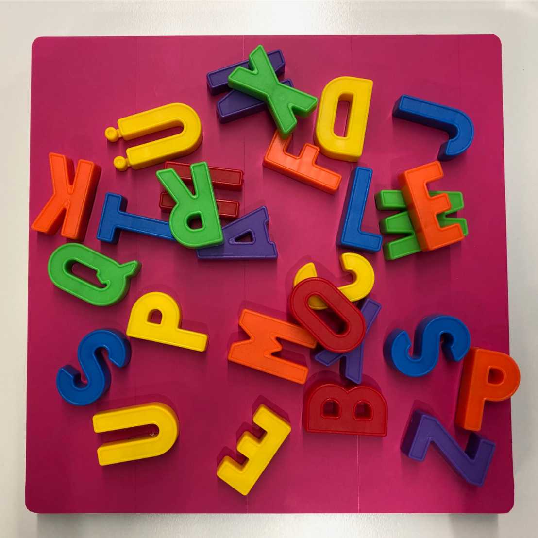 Bunte und ungeordnete Buchstaben aus Plastik