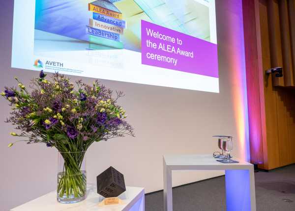 The podium with bouquet of flowers and in the background the welcome slide of the powerpoint presentation.